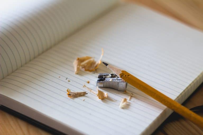 A sharpened pencil and shavings on a notebook
