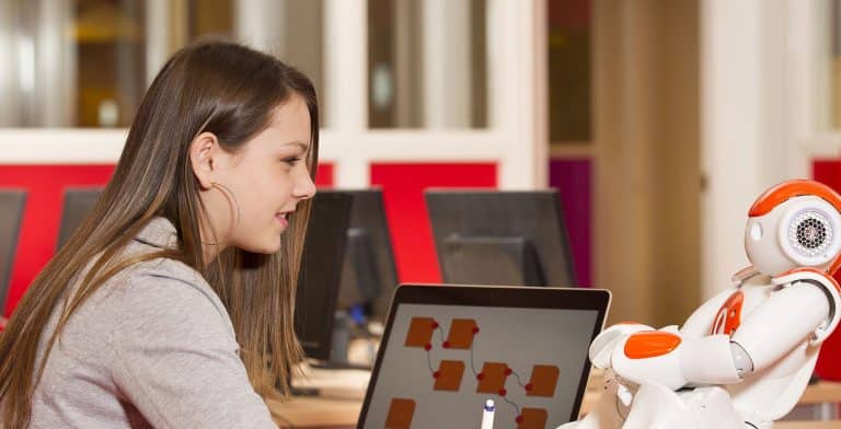 Teen girl with laptop and robot